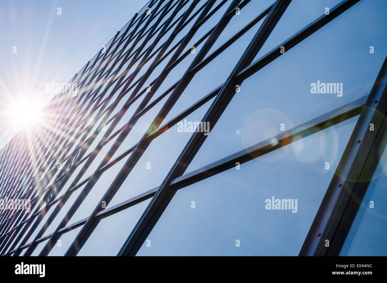 Glas und Stahl - verspiegelte Fassade des modernen Bürogebäude mit Sonnenstrahlen Blendung Reflexion Stockfoto