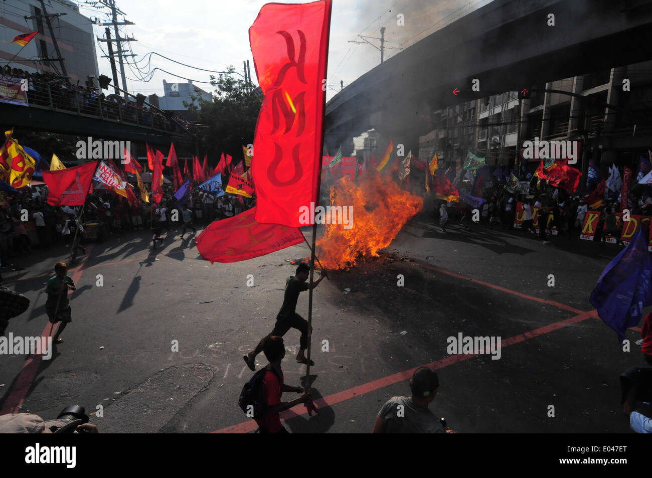 Manila, Philippinen. 1. Mai 2014. Mitglied der kann man Bewegung läuft um das Bildnis der philippinische Präsident Benigno Aquino III in Flammen verschlungen, als Tausende von Demonstranten marschierten in Richtung Mendiola Brücke vor den Toren des Präsidentenpalasts zum protest gegen die derzeitige Regierung Aquino. George Calvelo/NurPhoto/ZUMAPRESS.com/Alamy © Live-Nachrichten Stockfoto