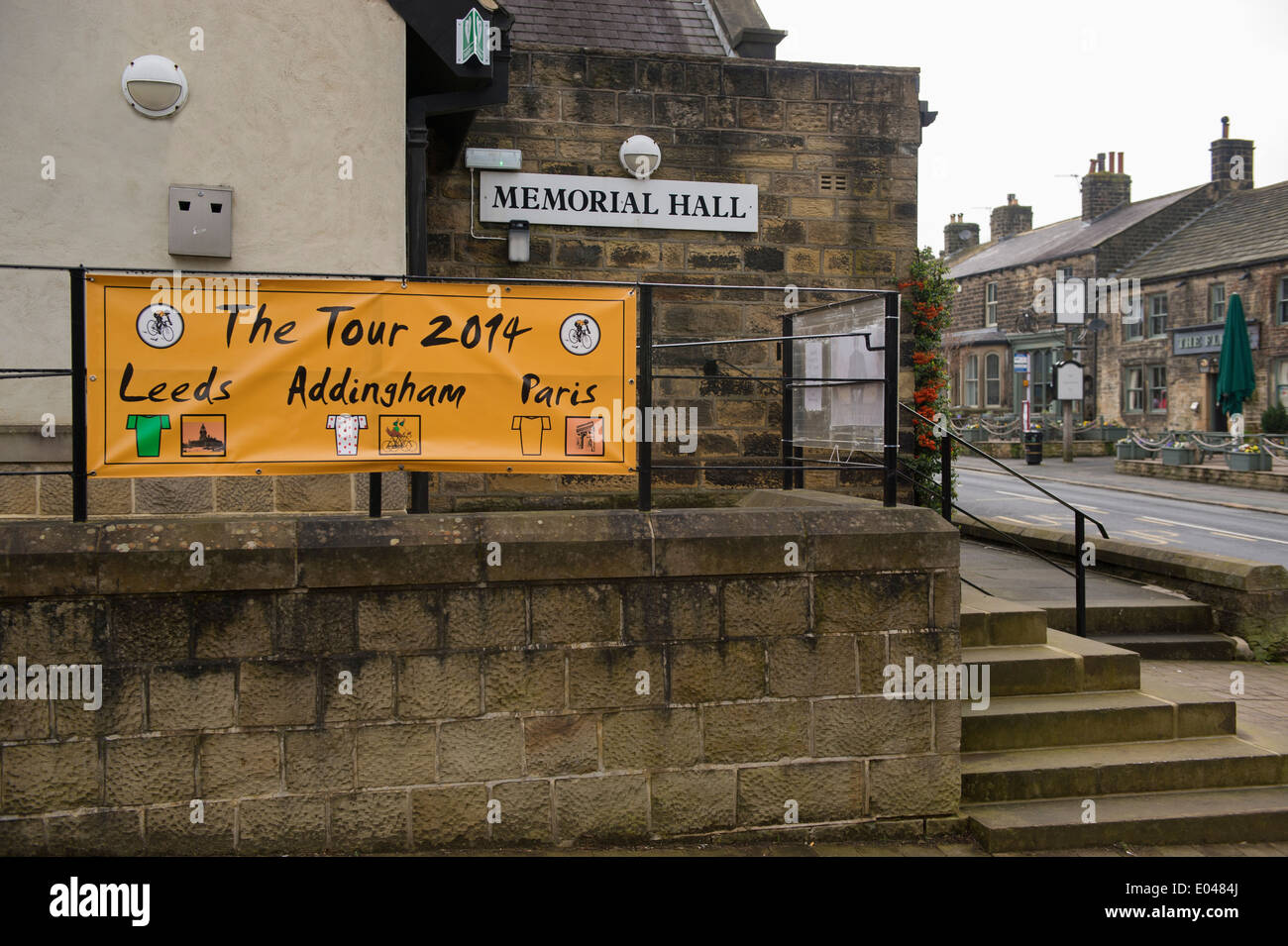 Orange Banner auf railingss ausserhalb des Dorfes Hall, platziert auf der Route der Tour de France begrüßt Besucher Addingham - West Yorkshire, England, UK. Stockfoto