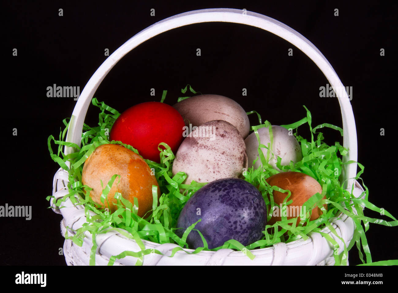 Weißen geflochtenen Korb gefüllt mit vielfarbigen Ostereier Stockfoto