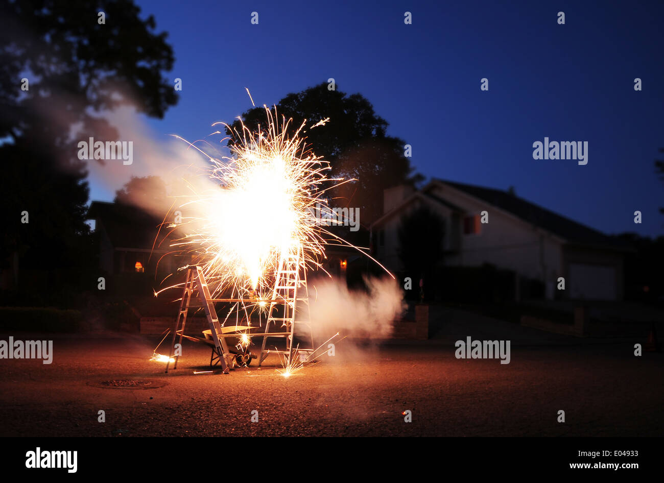 4. Juli Feuerwerk in einer Nachbarschaft. Feuerwerk auf einem Brett zwischen zwei Leitern. Stockfoto