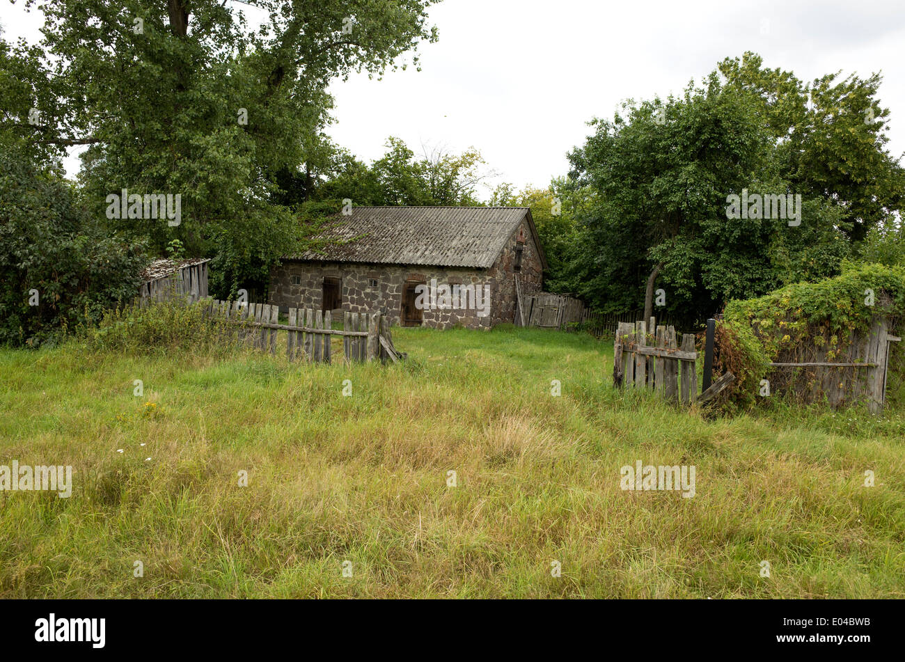 Vintage polnischen Bauernhof Gebäude aus Stein mit rustikalen Holz-Zaun. Zawady Zentralpolen Stockfoto