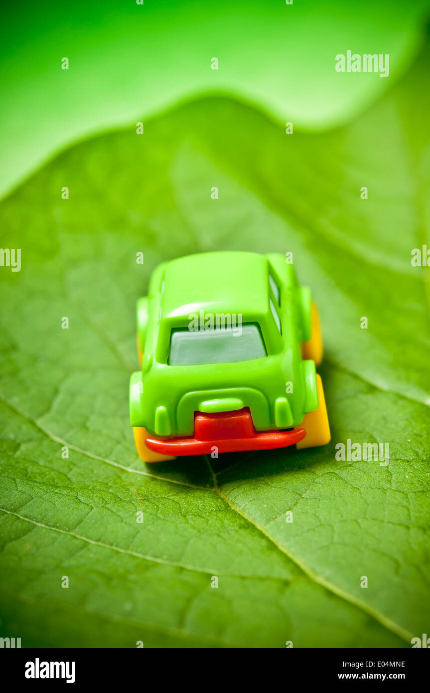 kleine grüne Spielzeugauto auf einem Blatt, Grün Auto Konzept Stockfoto