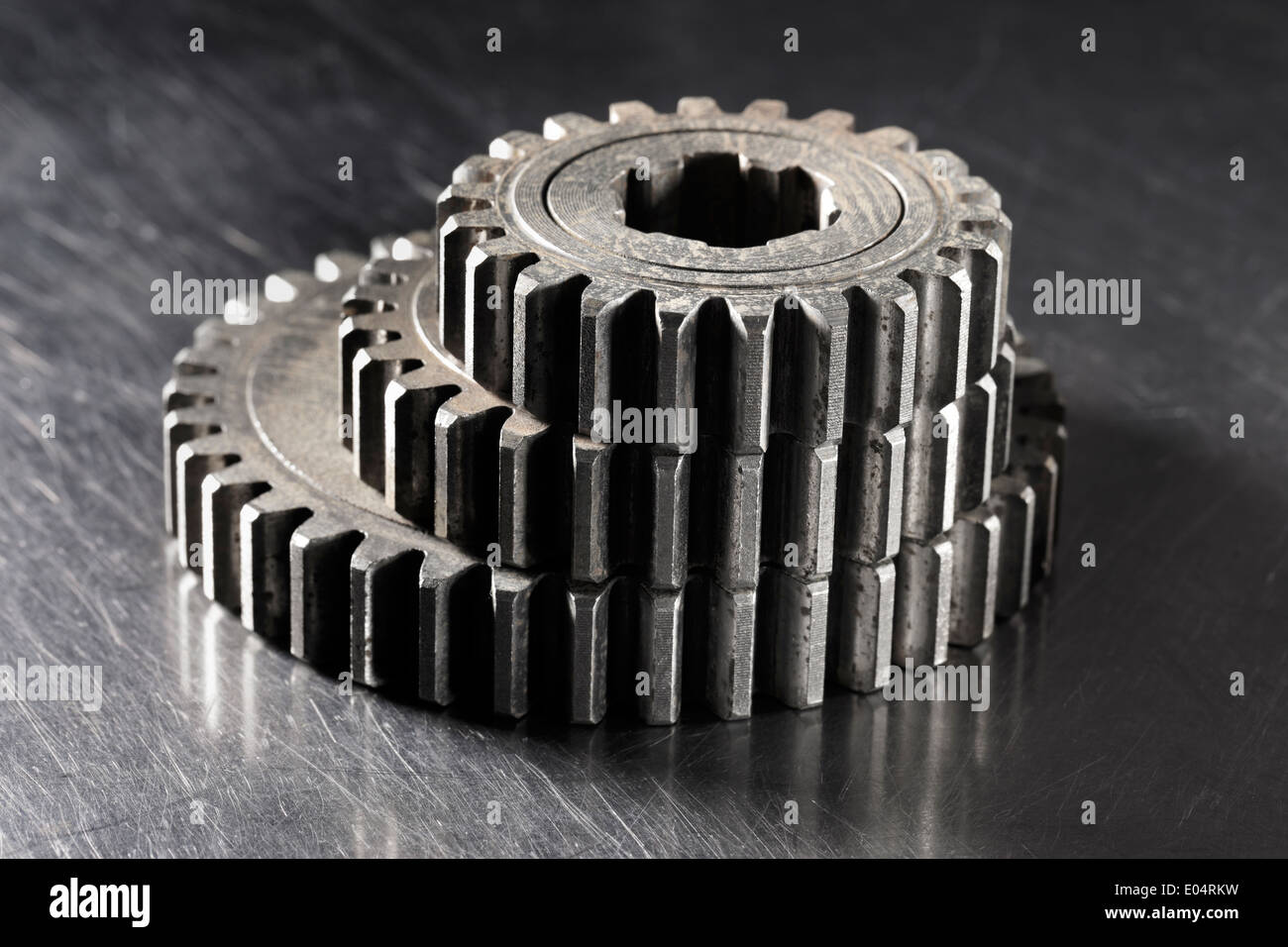Alten metallischen Zahnrad Zahnräder in verschiedenen Größen auf metallischen Hintergrund gestapelt. Stockfoto