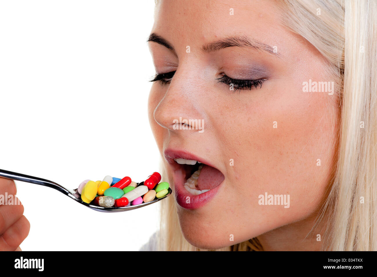 Junge Frau mit vielen Tabletten auf Löffel:, Junge Frau Mit Vielen Tabletten Auf Löffel: Stockfoto