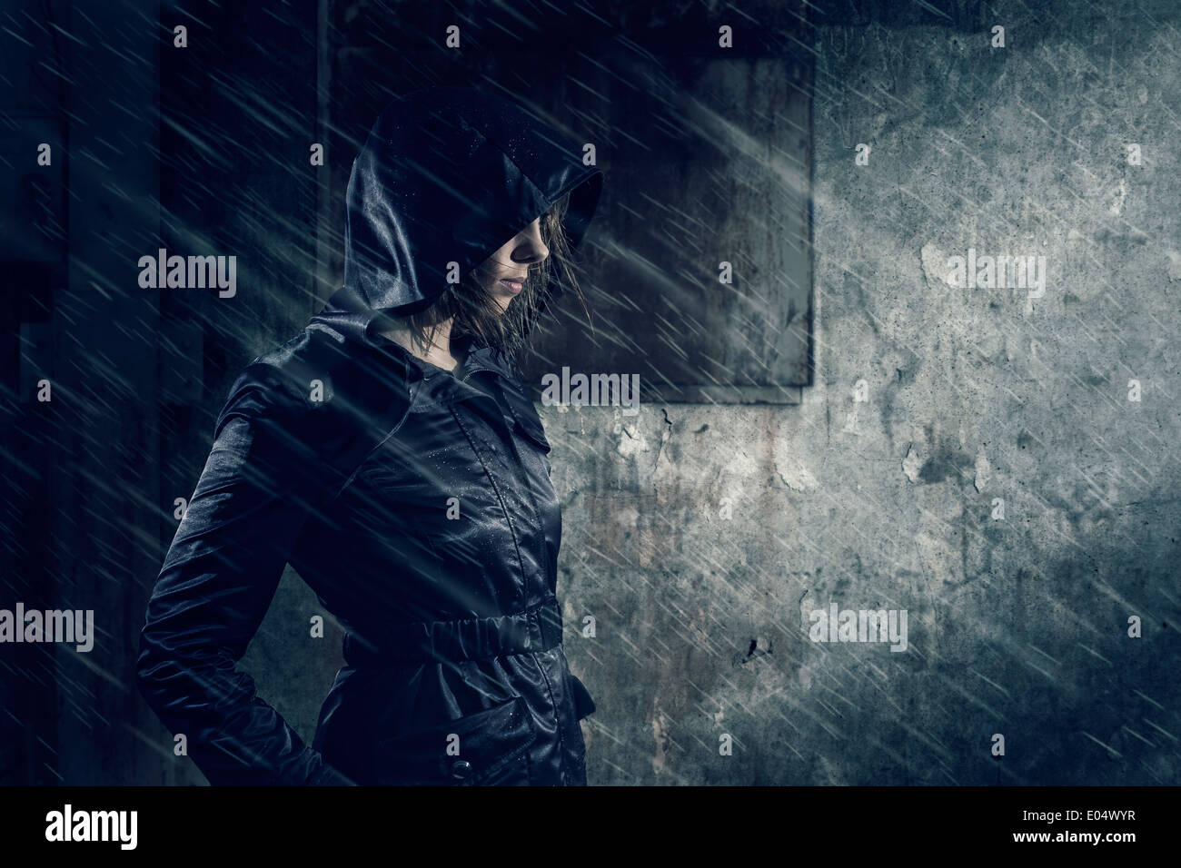 Frau in der Haube im Regen stehen Stockfoto