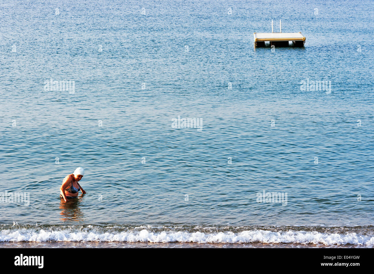Europa, Frankreich, Alpes-Maritimes Cannes. Alte Frau zu Fuß in Wasser. Stockfoto