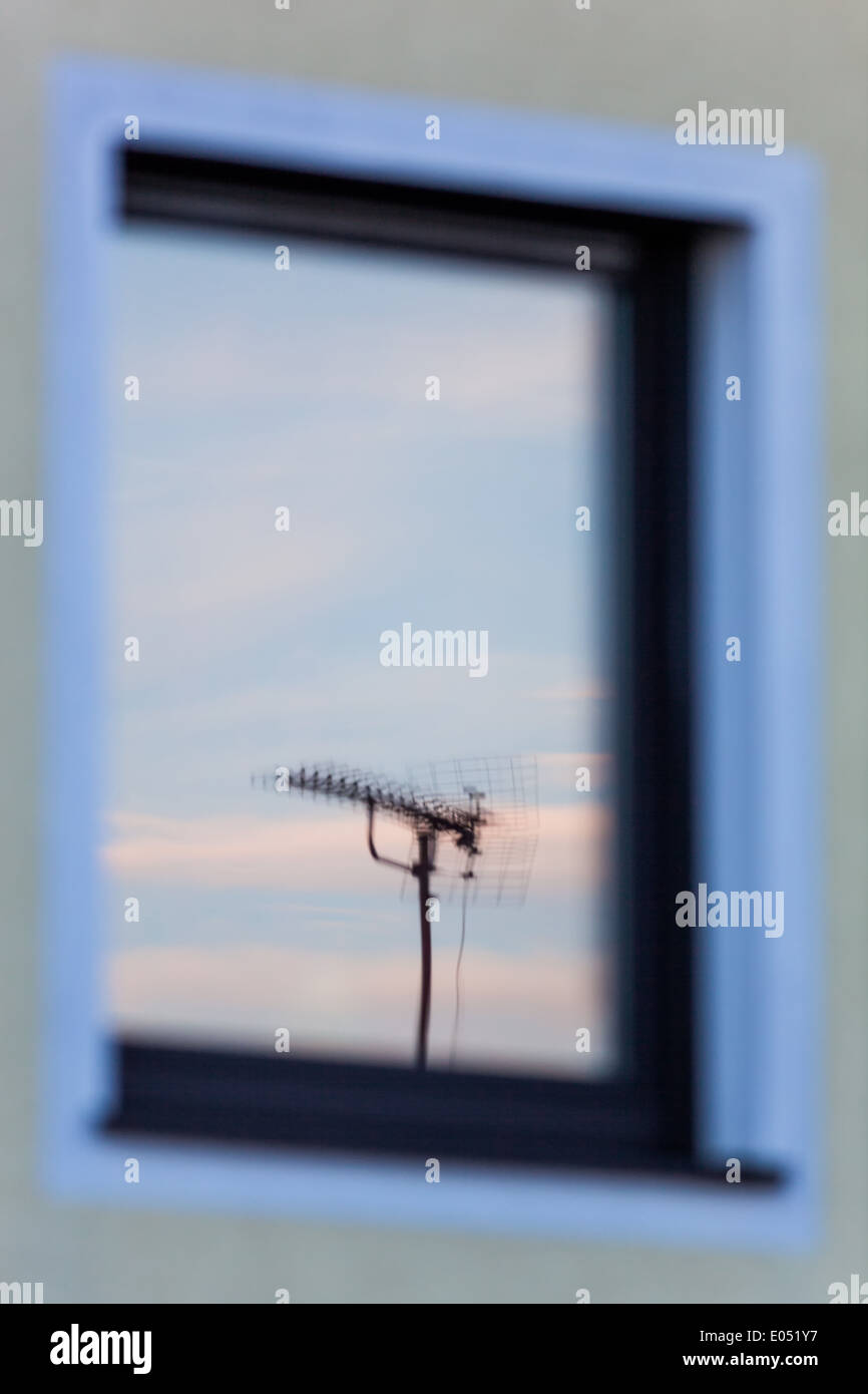 Eine Antenne für einen Fernseher spiegelt sich im Fenster eines Wohnhauses,  Eine Antenne Fuer Ein Fernsehgeraet Spiegelt sich Stockfotografie - Alamy