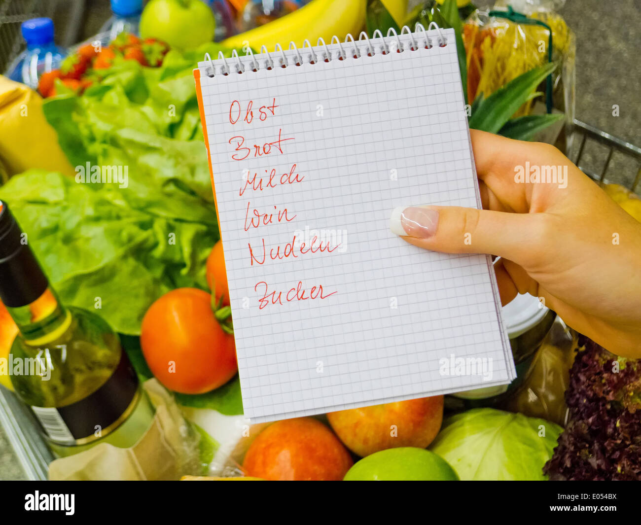 Eine Frau hält eine Einkaufsliste in einem Supermarkt in der Hand. Deutsch: Eine Frau Hält Einen Einkaufszettel in Einem Supermarkt in Stockfoto