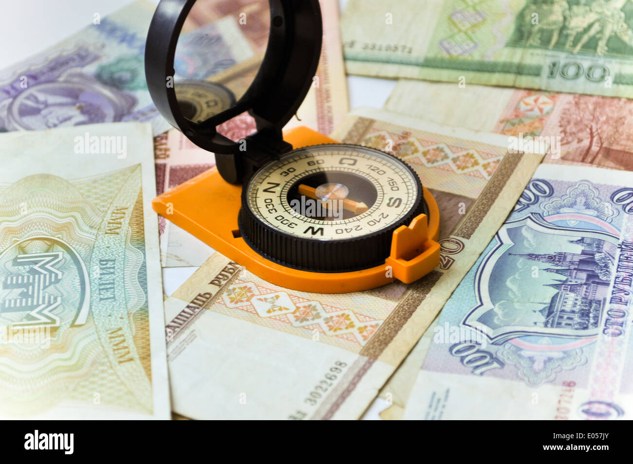 Banknoten und Kompass. Navigation in der Welt der Finanzen. Auf einem weißen Hintergrund sind alte Banknoten, ist ein Kompass. Stockfoto