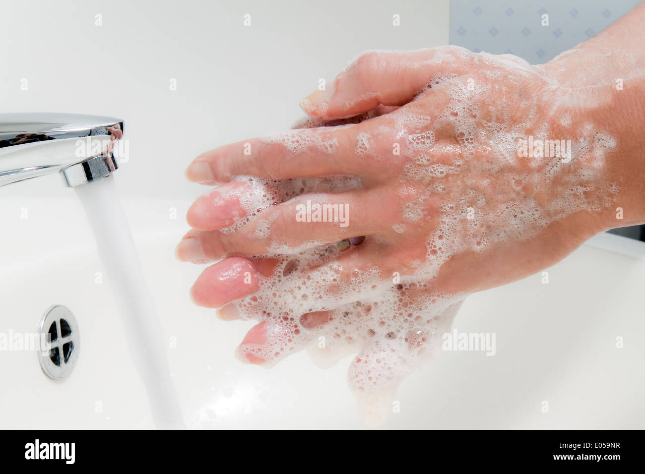 Frau wäscht sich die Hände mit fließend Wasser und Seife. Infektionsschutz der neuen Grippe, Frau Waescht Sitsch Stockfoto