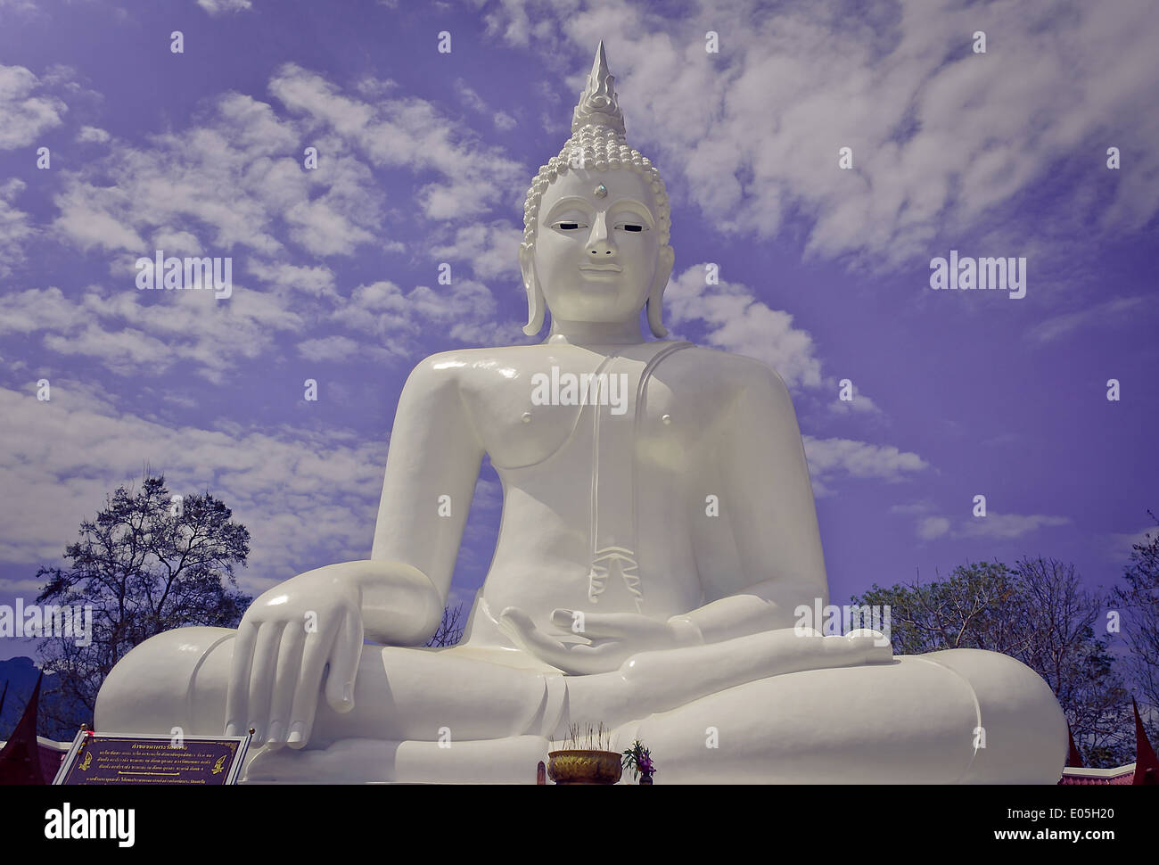 Weiß sitzende Buddha-Statue mit bewölktem Himmelshintergrund Stockfoto