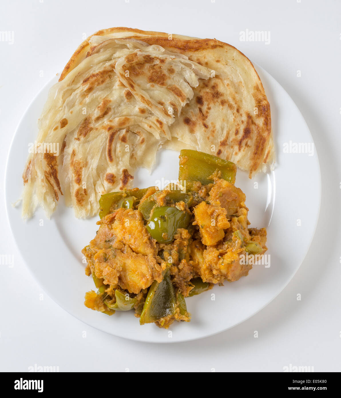 Aloo Paprika, Kartoffeln und Paprika vegetarische Curry serviert mit Fladenbrot gebraten Paratha in der traditionellen Weise von oben Stockfoto