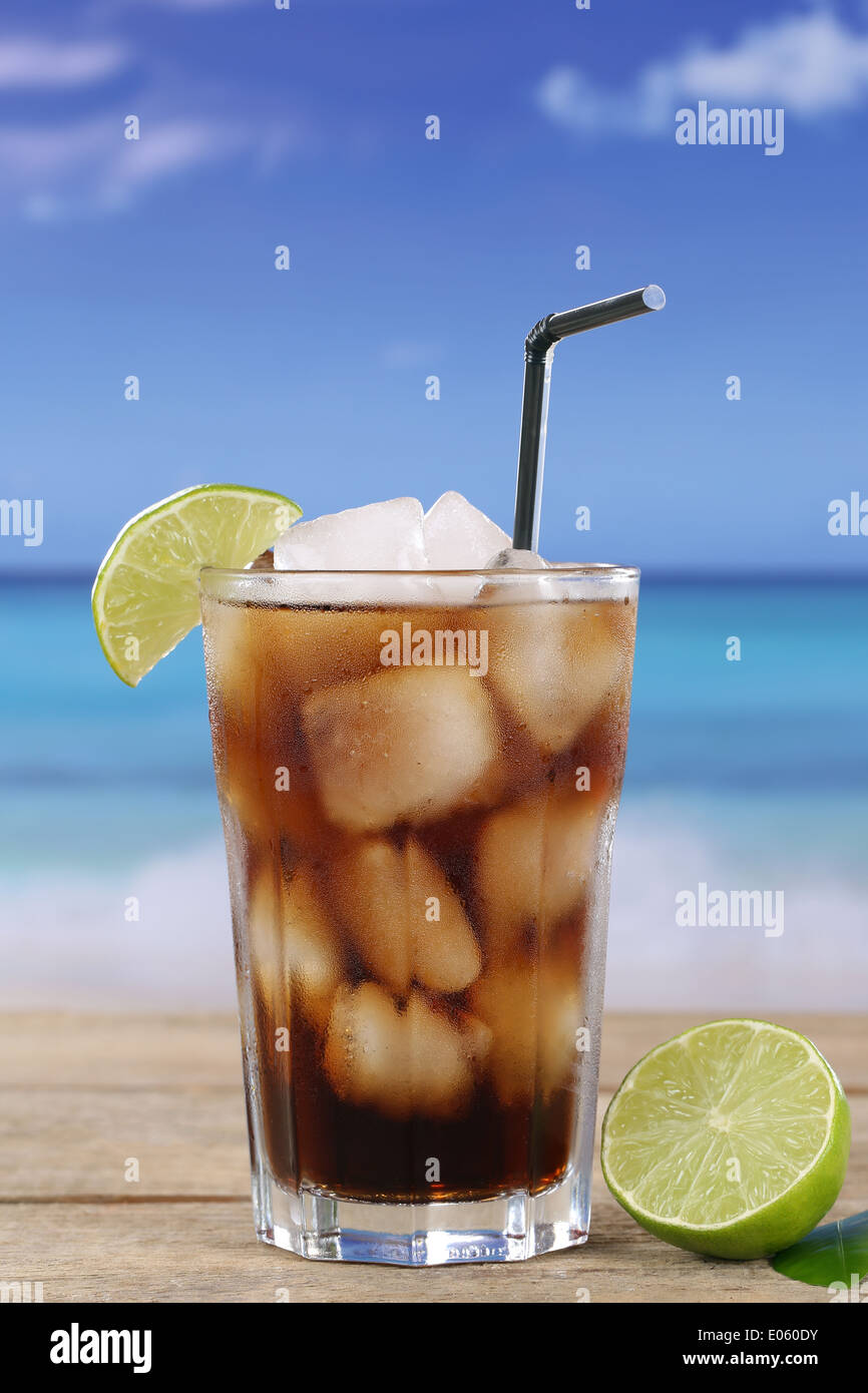 Kalte Cola trinken im Glas mit Eiswürfeln und Kalk am Strand Stockfoto