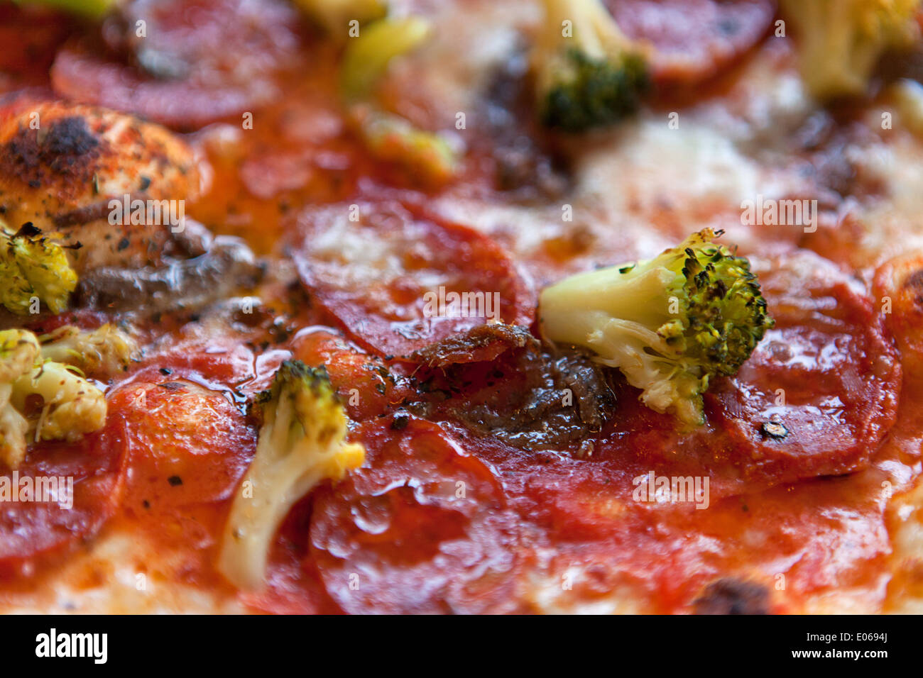 Pizza mit italienischer Salami, Brokkoli, Tomaten und Käse Stockfoto