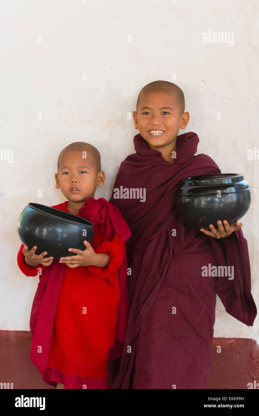 Junge Mönche halten Almosen Wok, Bagan, Myanmar Stockfoto