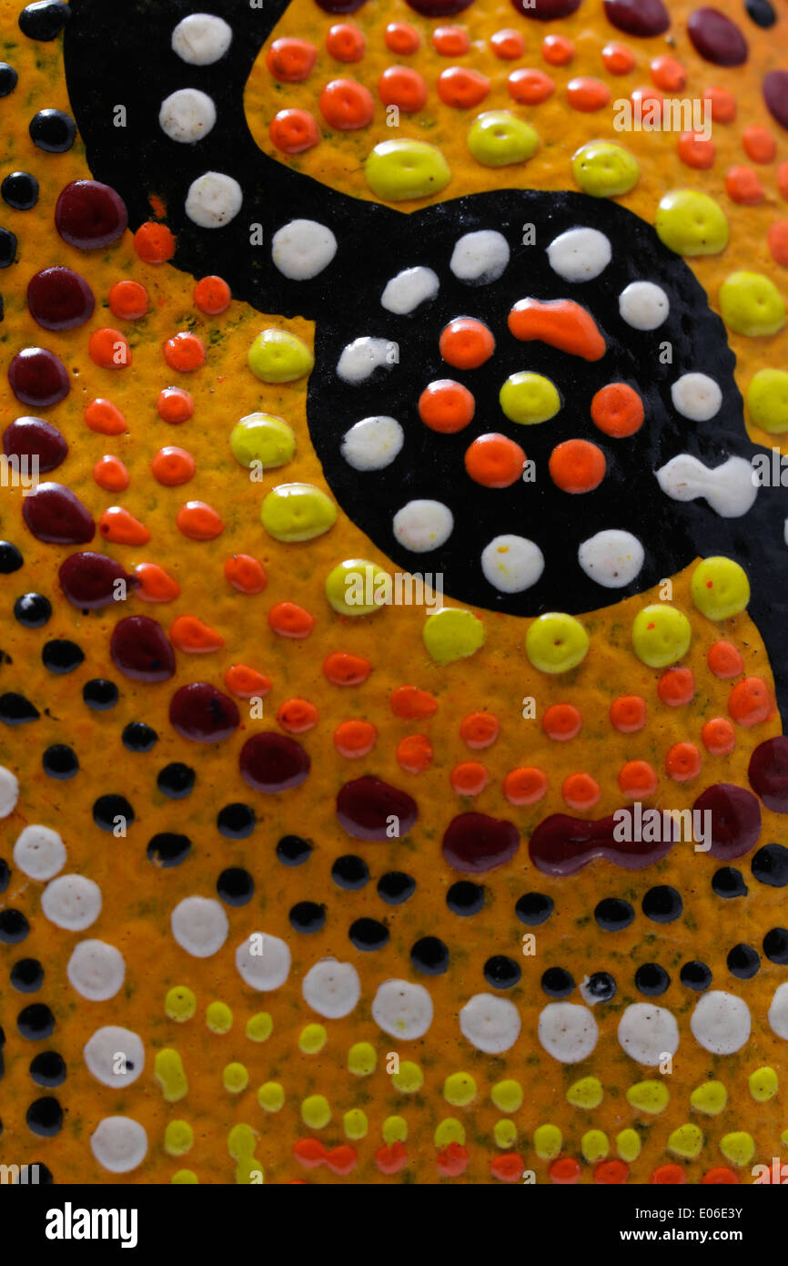 Nahaufnahme Detail eine bunte australischen Aborigines handbemalt Dot Malerei, auf einem geschnitzten hölzernen Souvenir vorgestellt. Stockfoto