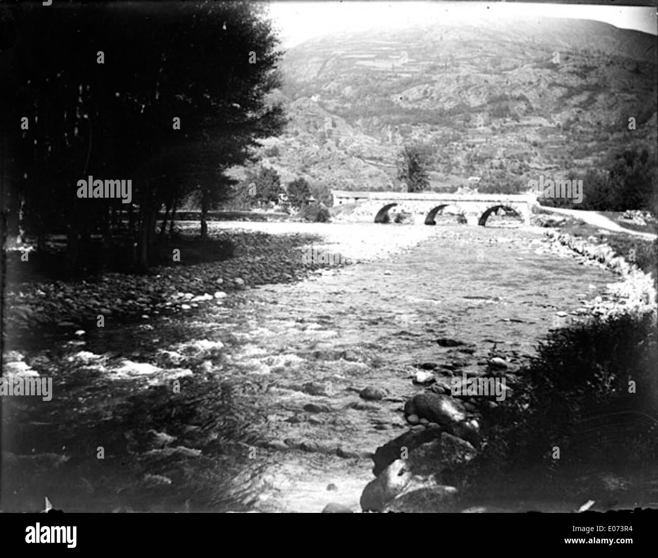 Dieses Bild, das in der Bibliothèque de Toulouse untergebracht ist, zeigt einen Fluss und eine Brücke in der Mittelgebirgsregion. Es zeigt die malerische Landschaft und architektonische Elemente, die das ländliche Frankreich im historischen Kontext charakterisieren. Stockfoto