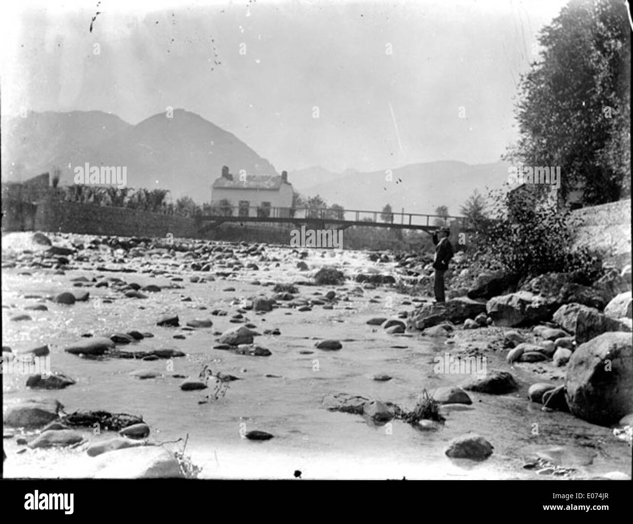 Beleuchteten d ' une Rivière En Moyenne Montagne Avec un Homme Sur la rive Stockfoto