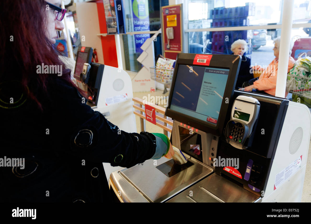 Eine junge Frau mit den Scan, wie Sie bis in Tesco Supermarkt einkaufen Stockfoto