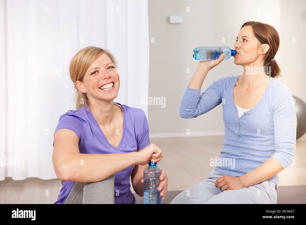 Frauen trinken von Wasser in Flaschen auf Pilates-Klasse Stockfoto