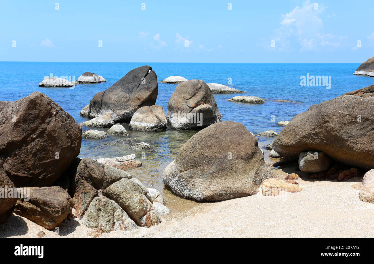 Steinen am Strand am Meer auf einem Hintergrund des blauen Himmels Stockfoto