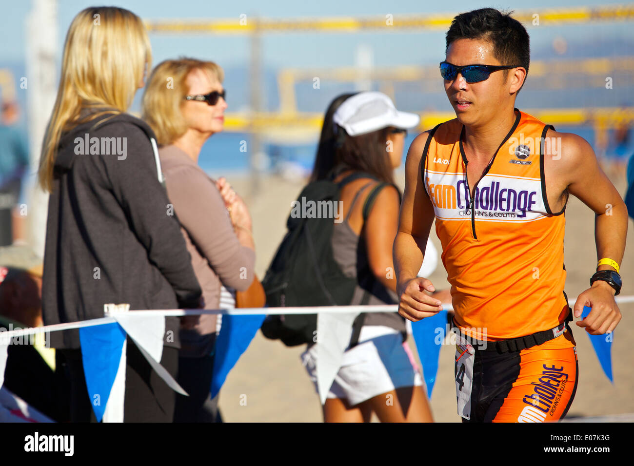 Chinesische amerikanische männliche Athlet nähert sich der Ziellinie am Hermosa Beach Triathlon 2013, Los Angeles, Kalifornien. Stockfoto