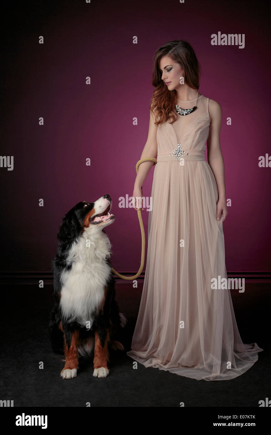 Junge Frau im Abendkleid mit Hund Stockfoto