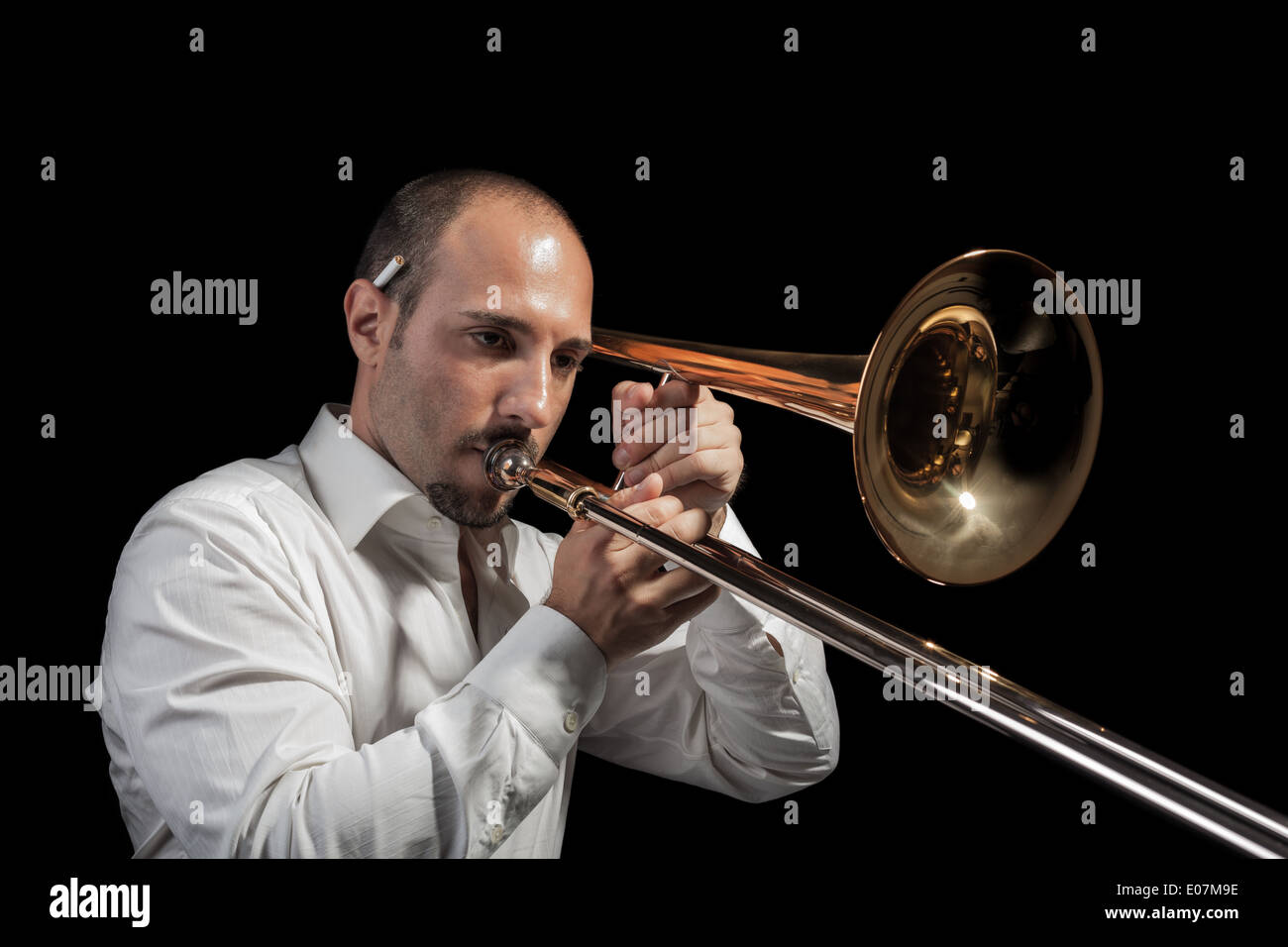 ein junger Jazzer mit Posaune über schwarzen Hintergrund Stockfoto