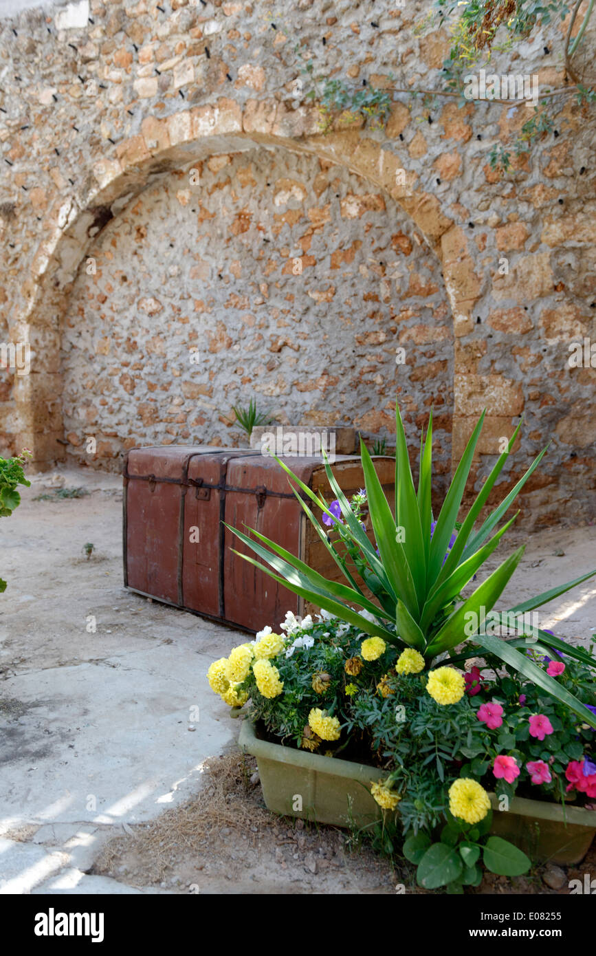 Rustikale Garten mit bunten Blumen alten Stamm Steinmauer mit Bogen