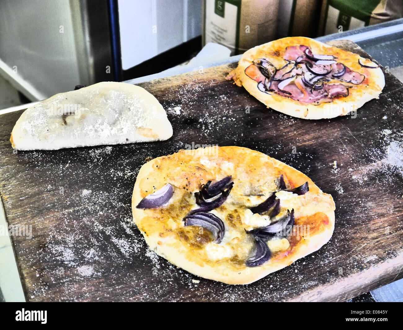 Zubereitung von Speisen - Pizza mit roten Zwiebeln auf hölzernen Vorbereitungstisch Stockfoto