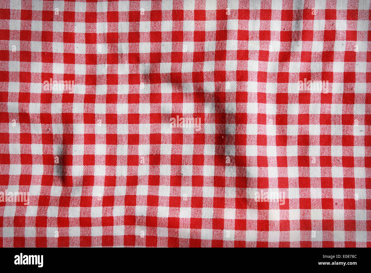 Textur von einer rot-weiß karierten Picknickdecke. Rote Wäsche zerknittert Tischdecke. Stockfoto