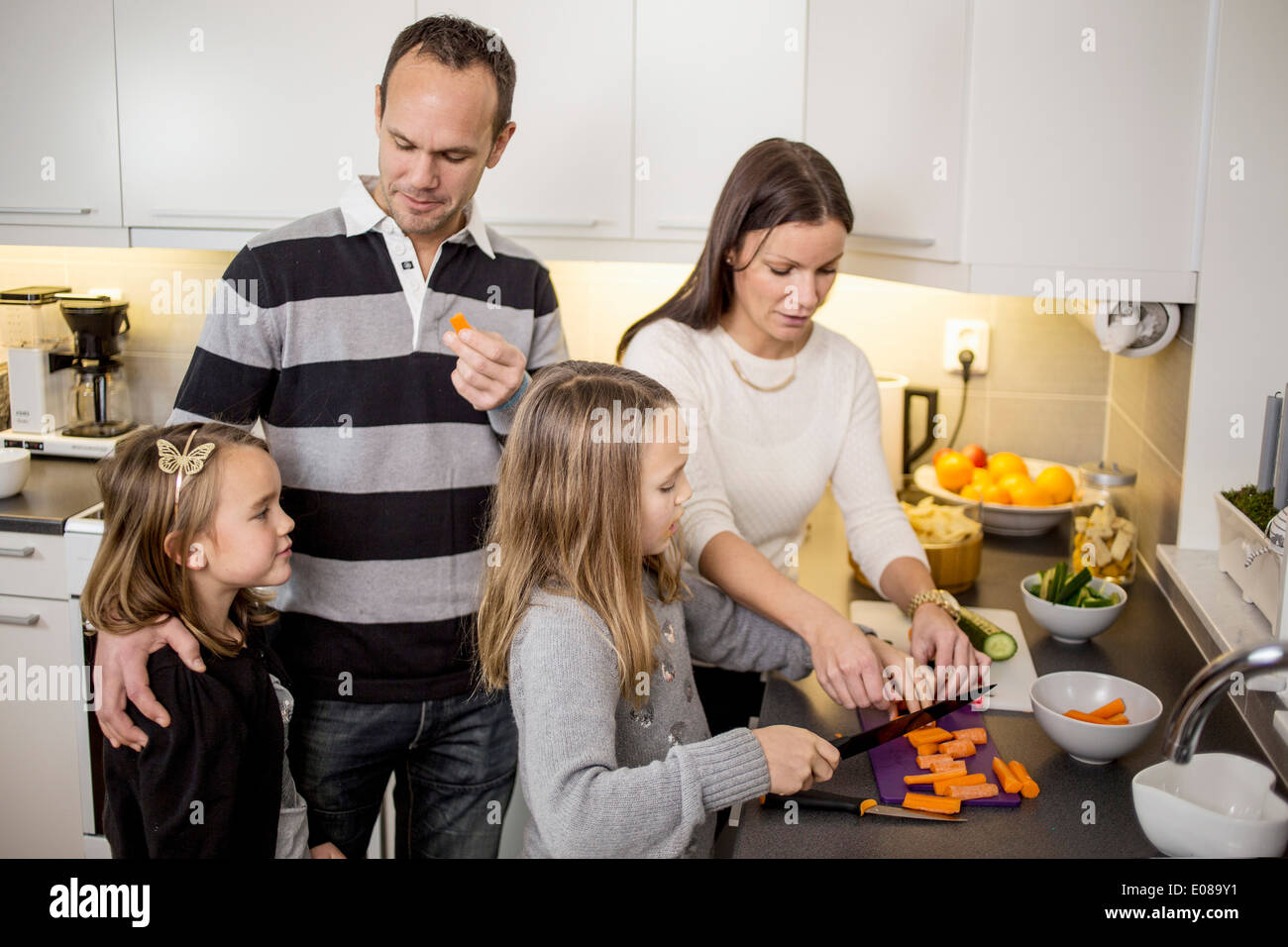 Familie Schneiden von Gemüse am Küchentisch Stockfoto