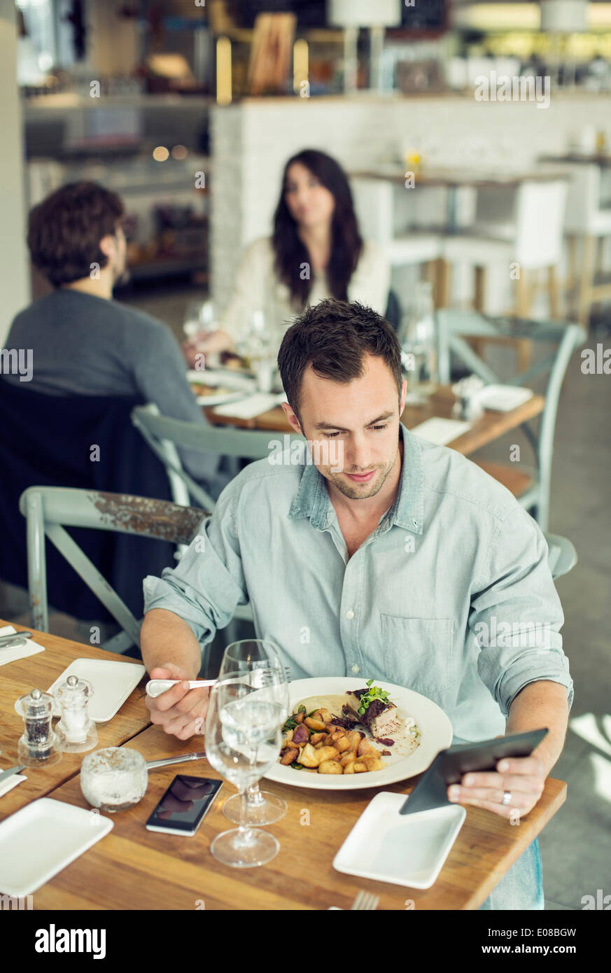 Mitte adult Geschäftsmann mit digital-Tablette während dem Mittagessen im restaurant Stockfoto