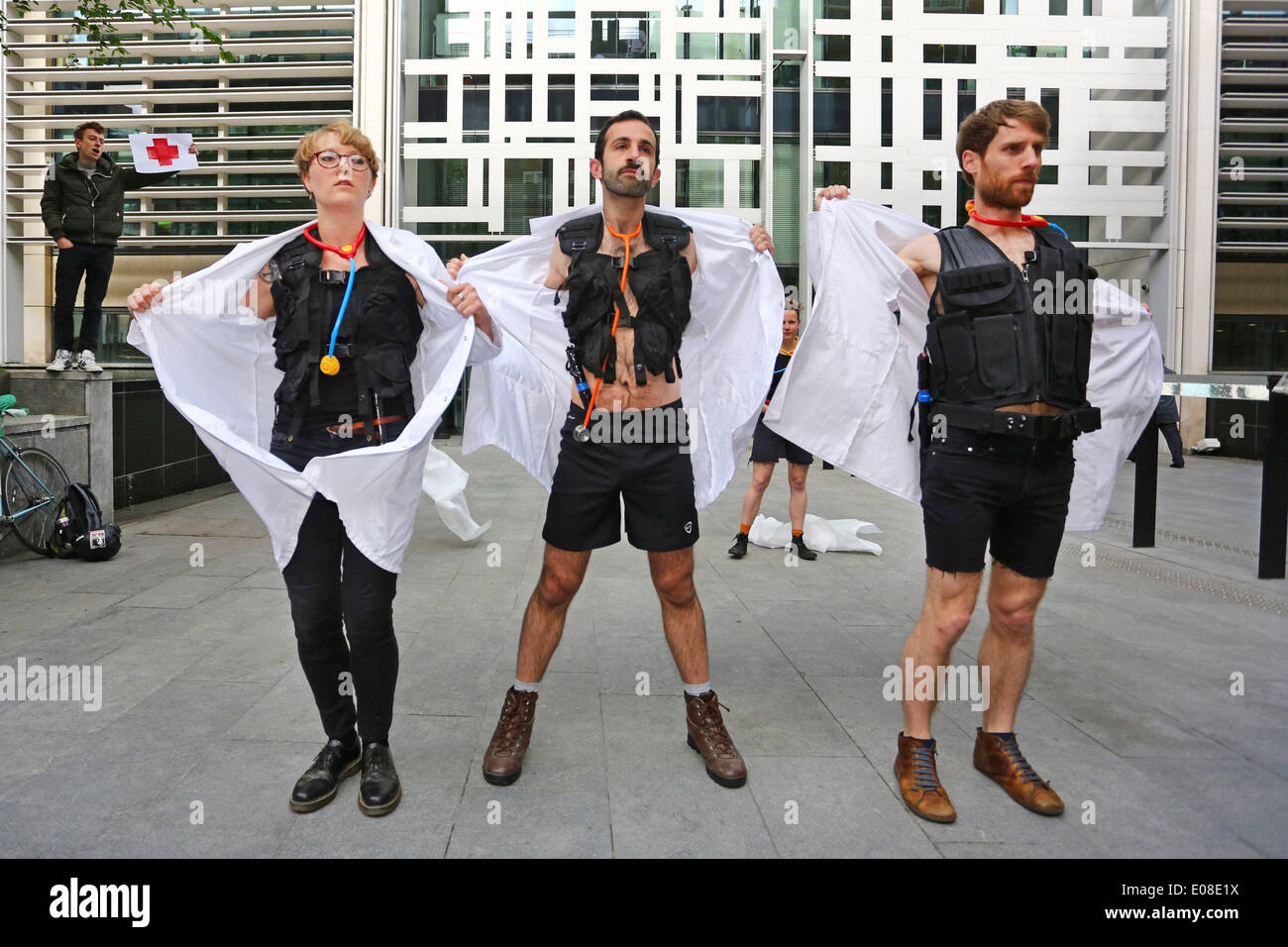London, UK. 6. Mai 2014. Act Up Docs nicht Cops Einwanderungsgesetz protestieren im Home Office in London mit Demonstranten verkleidet als Ärzte zu Polizei abstreifen. ACT UP London kämpft gegen zwei Klauseln in der Immigration-Rechnung, die dazu dienen, Kosten für Gesundheitsdienstleistungen einführen, Ärzte in Grenzbeamten verwandeln und HIV-Infektion erhöhen. Bildnachweis: Paul Brown/Alamy Live-Nachrichten Stockfoto
