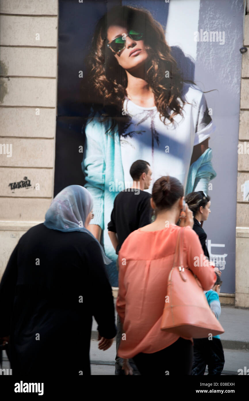 Menschen gehen vorbei an der Dixit Bekleidungsgeschäft, einschließlich einer älteren Frau trägt ein Kopftuch und eine junge Frau entdeckt Stockfoto