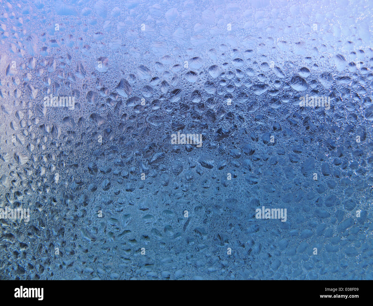 Wassertropfen und Frost auf Fensterglas Stockfoto