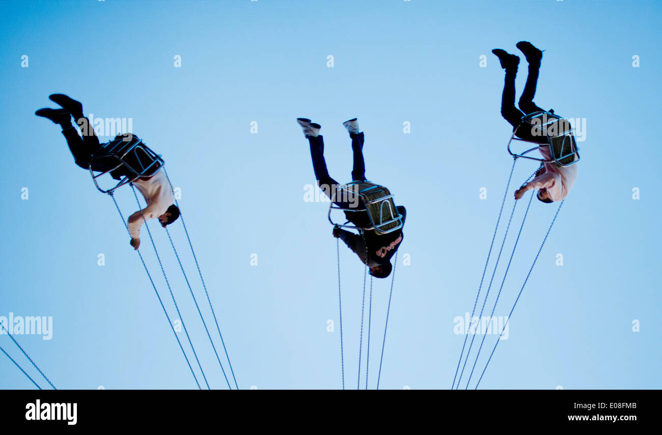 Drei junge Männer sitzen in einem Messegelände fahren beim Frühlingsfest in Hannover, Deutschland, 5. Mai 2014. Foto: JULIAN STRATENSCHULTE/DPA Stockfoto