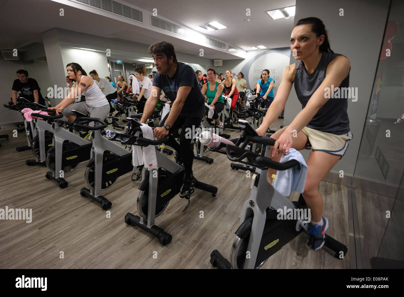 Menschen auf stationären Fahrrädern während einem Spinning Kurs in der Turnhalle Stockfoto