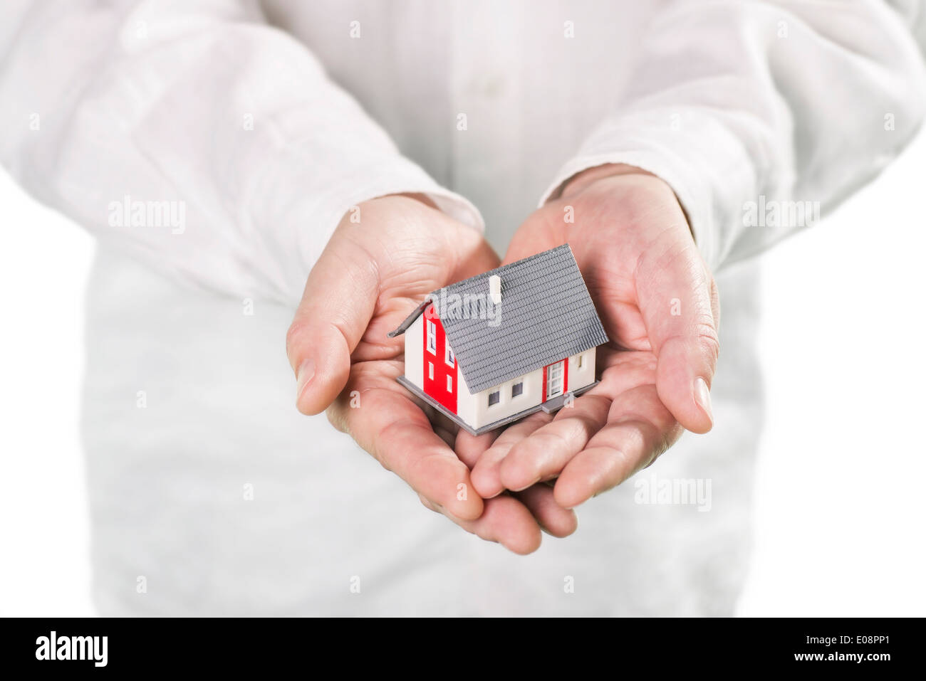 Hände halten ein Haus sorgfältig. Stockfoto Hände halten ein Haus sorgfältig. Stockfoto