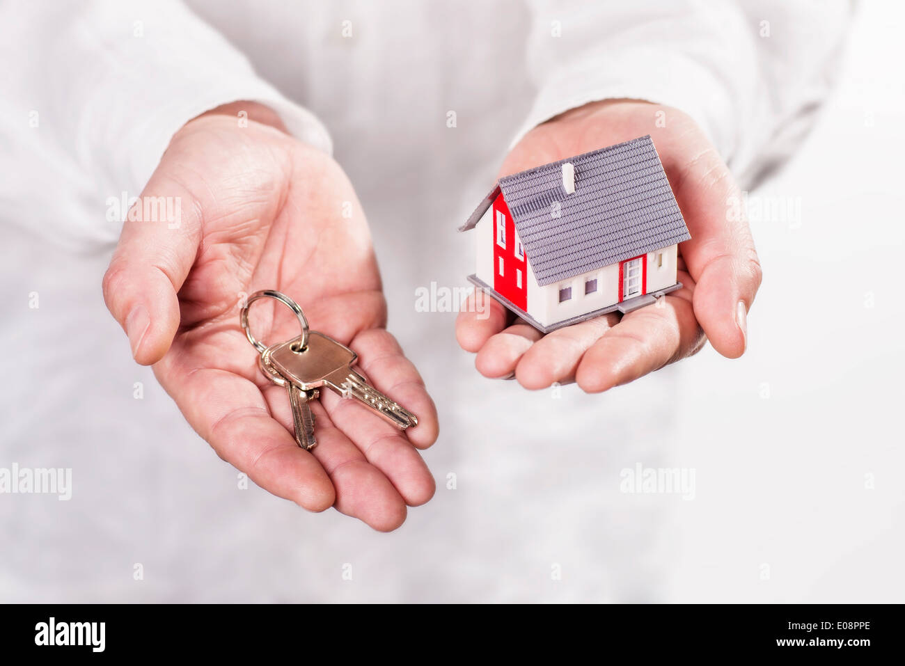 Hände halten ein Haus und Schlüssel. Stockfoto