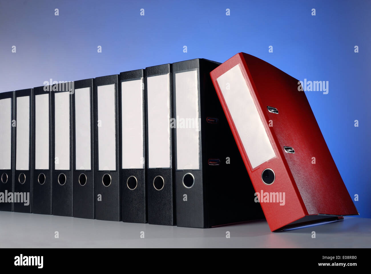 Ein roter Ringordner und eine Reihe schwarzer Feilen. Stockfoto