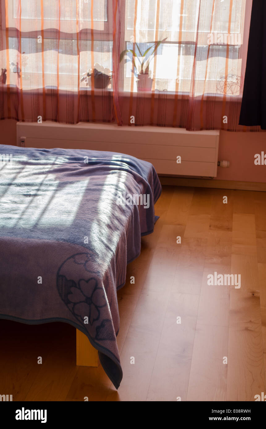 Sonnenschutz spiegelt sich durch den Vorhang auf die Bett Bettdecken Stockfoto