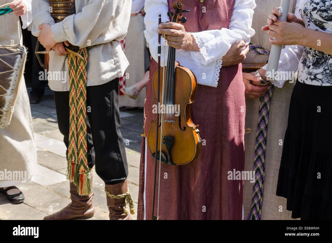 Folk-Musiker mit traditionellen Kleidern mit gewebten Bändern. weibliche Hand halten Violine. Stockfoto