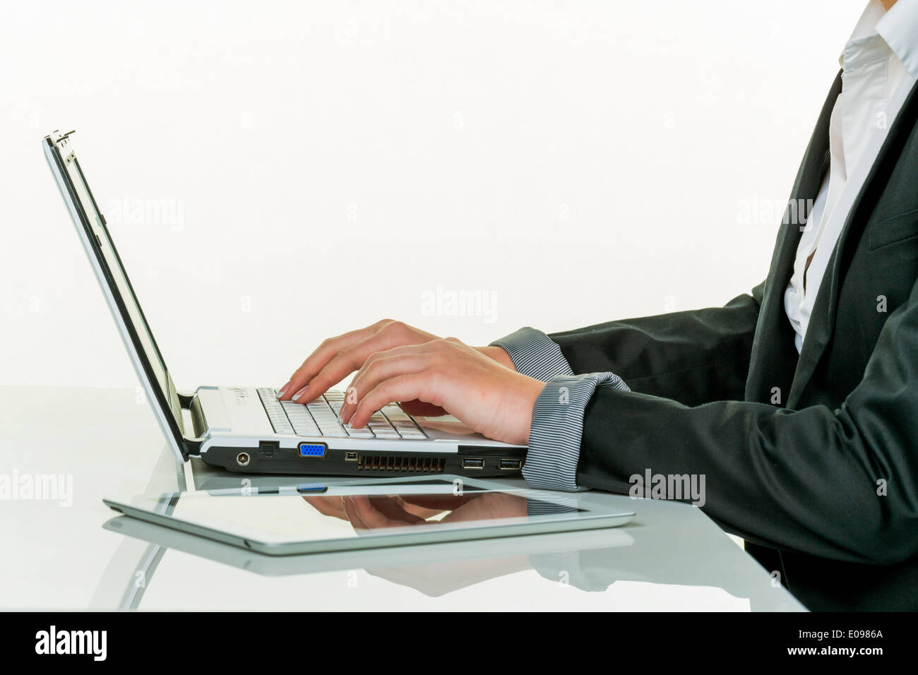 Eine Frau arbeitet in einem Büro mit einem Laptop-Computer, Eine Frau Arbeitet in Einem Büro Mit Einem Laptop-Computer Stockfoto
