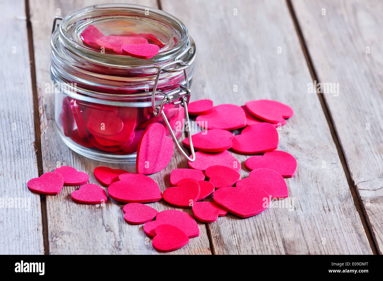 Rote Herzen in einem geschlossenen und verriegelten transparente Glas auf alten Holztisch. Selektiven Fokus. Stockfoto