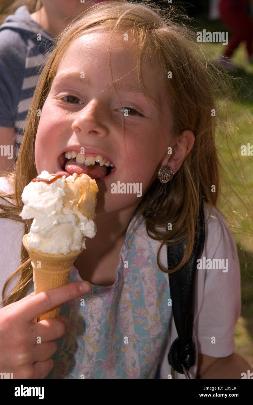 8-Jähriges Mädchen genießen ein Eis im Mai fayre oakhanger, oakhanger, Hampshire, UK. Stockfoto