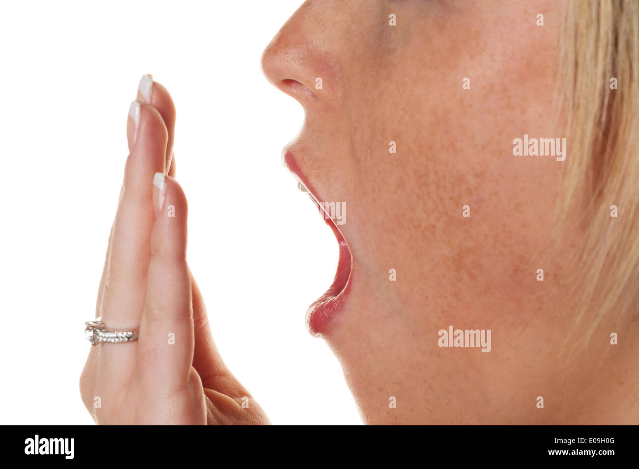 Eine junge Frau hält die Hand vor den Mund mit dem Gähnen. Müdigkeit und Schlaf Mangel, Eine Junge Frau Haelt Sich Beim Gaehne Stockfoto
