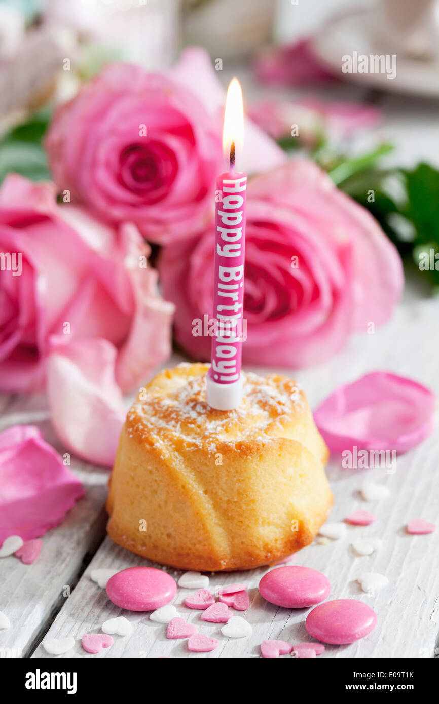 Muffin mit beleuchteten Geburtstag Kerze, Backen Dekor und rosa Rosen ...