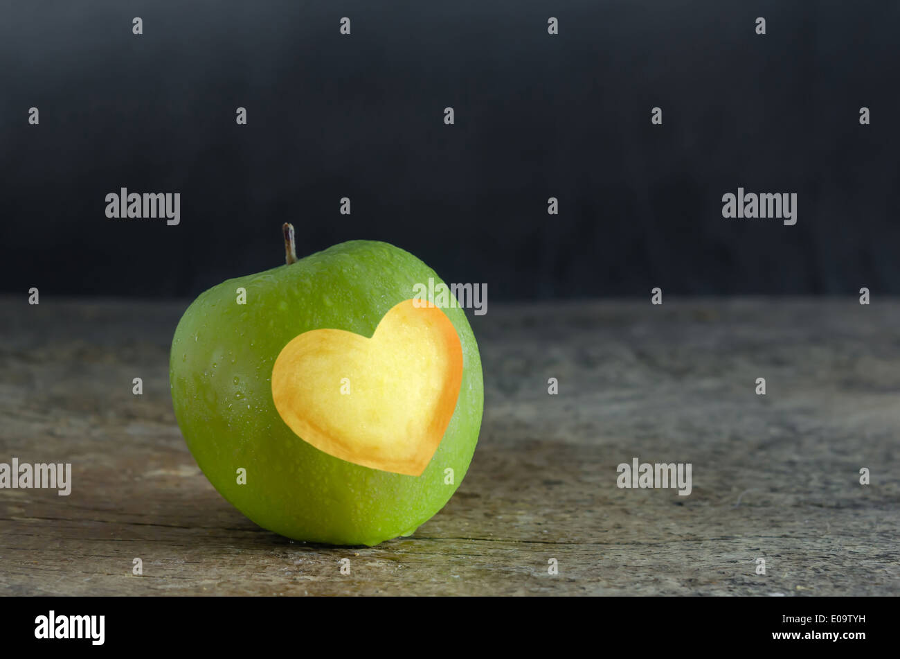 Stillleben, grüner Apfel mit Herzform auf hölzernen abgeschnitten Stockfoto